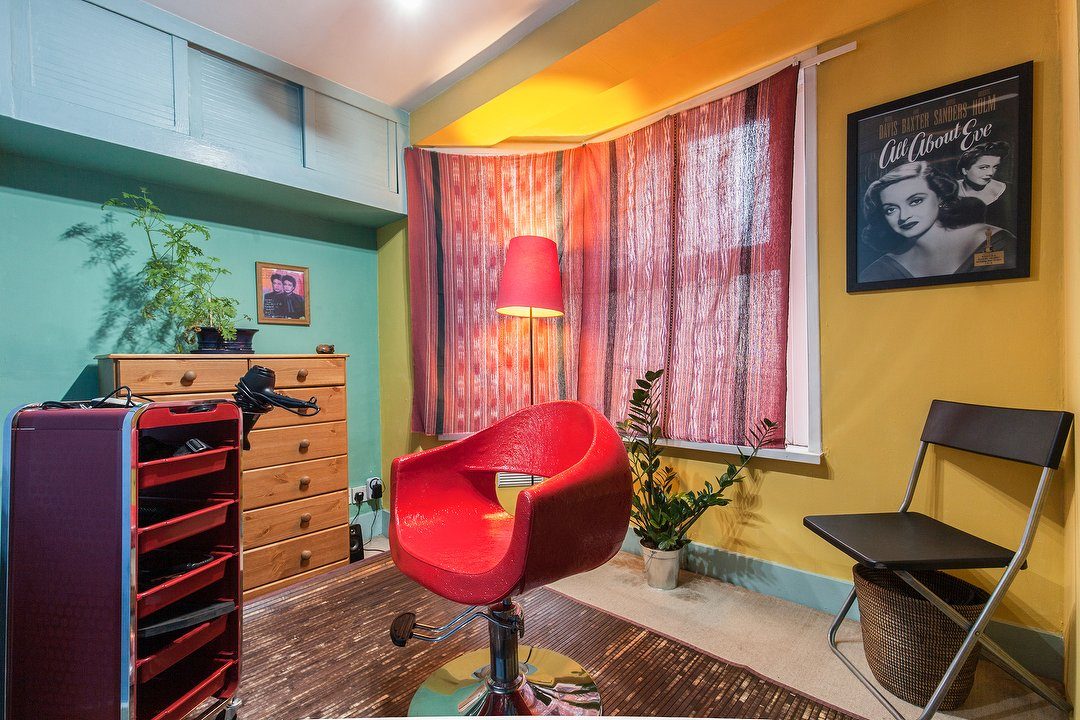 Hair by Gerry's studio in East Dulwich — teal and yellow walls, vintage film posters and a red styling chair